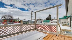 A wooden deck with a lattice railing, a view of a neighborhood, and a clear sky. - Dog-friendly Montana Home w/ Deck & Fenced-in Yard (Dillon)