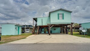 A two-story building with a covered porch and a staircase leading to the upper level. - Charming Home w/ Dock, Near Downtown Lake Charles! (Lake Charles)