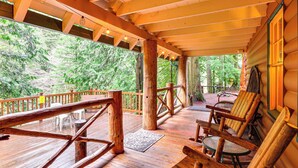 A wooden deck with outdoor seating and a view of a forest. - Forested 'minikahda Lodge' w/ Hot Tub Near Mt Hood (Rhododendron)