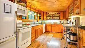 A kitchen with wooden cabinets, a white refrigerator, a stove, and a microwave. - Forested 'minikahda Lodge' w/ Hot Tub Near Mt Hood (Rhododendron)