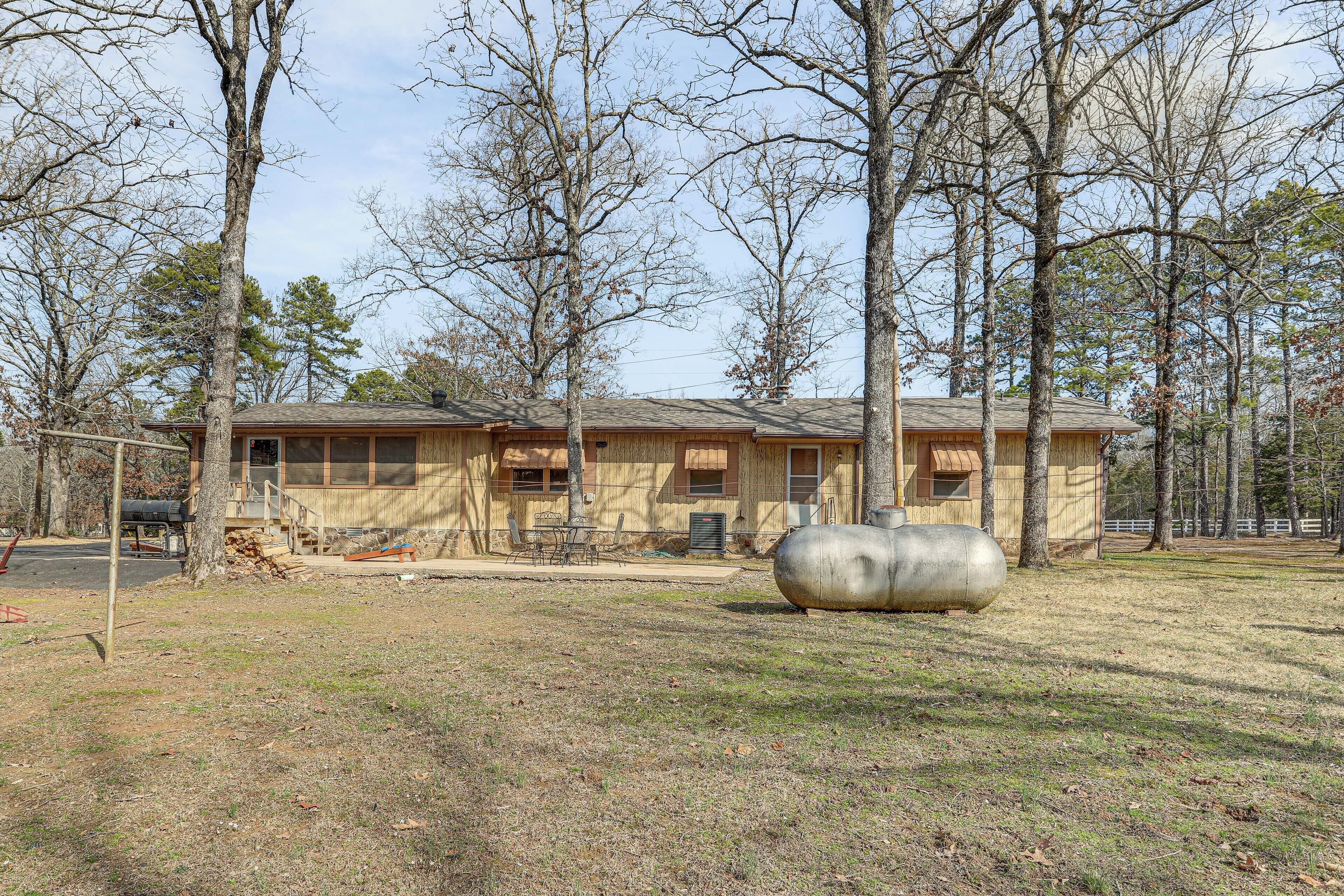 A two-story house with a large front porch, a covered outdoor seating area, and a large cylindrical object in the yard.