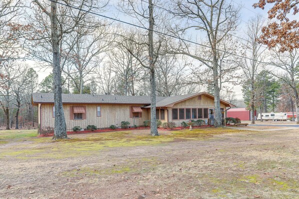 A single-story wooden cabin with a sloped roof, a front porch, and a covered outdoor area.