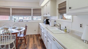 A kitchen with a dining table, chairs, a sink, cabinets, and a window with blinds. - Pet-friendly Higden Getaway < 1 Mi to Marina! (Higden)
