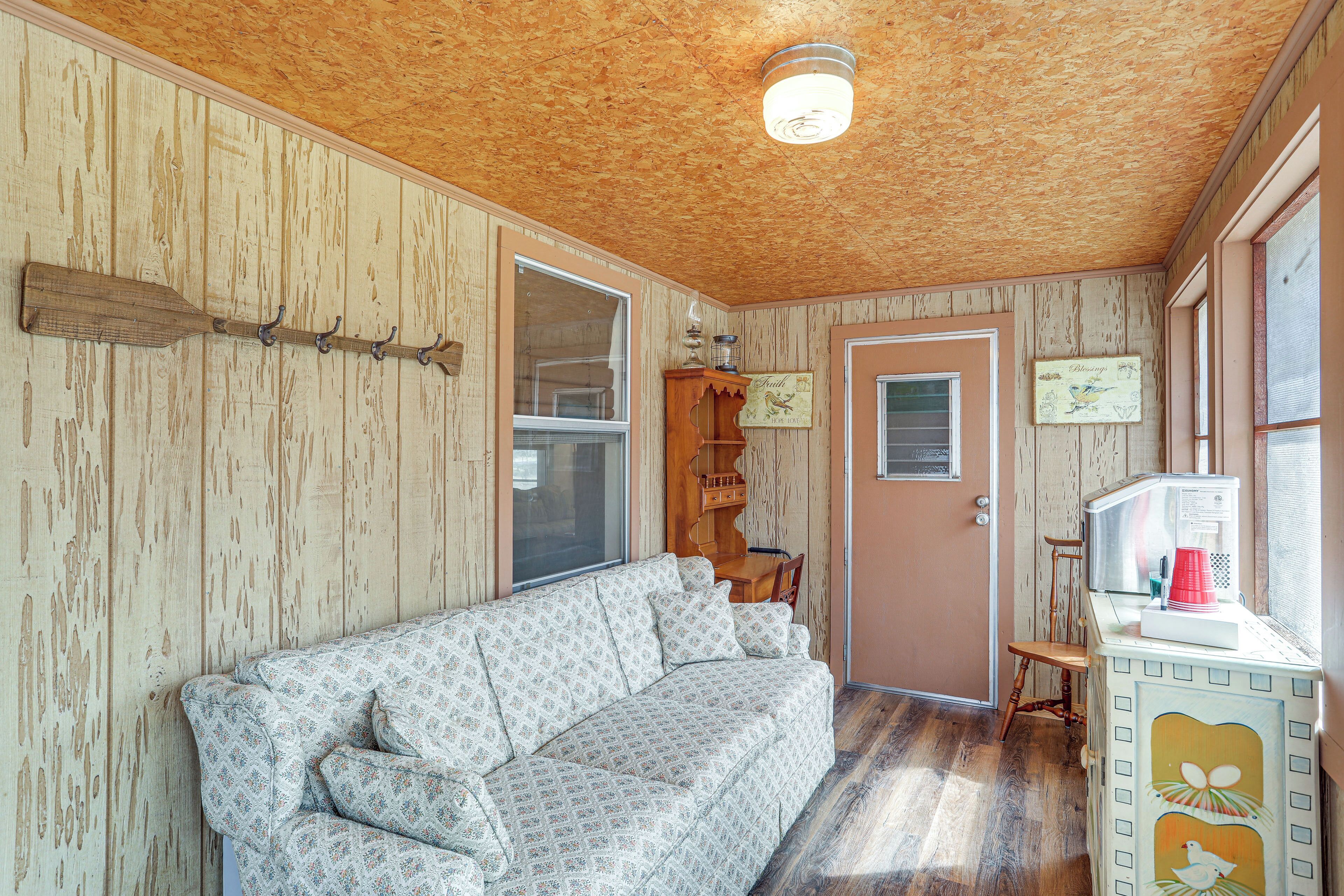 Une pièce avec un plafond en bois, un canapé, un meuble en bois et une porte.