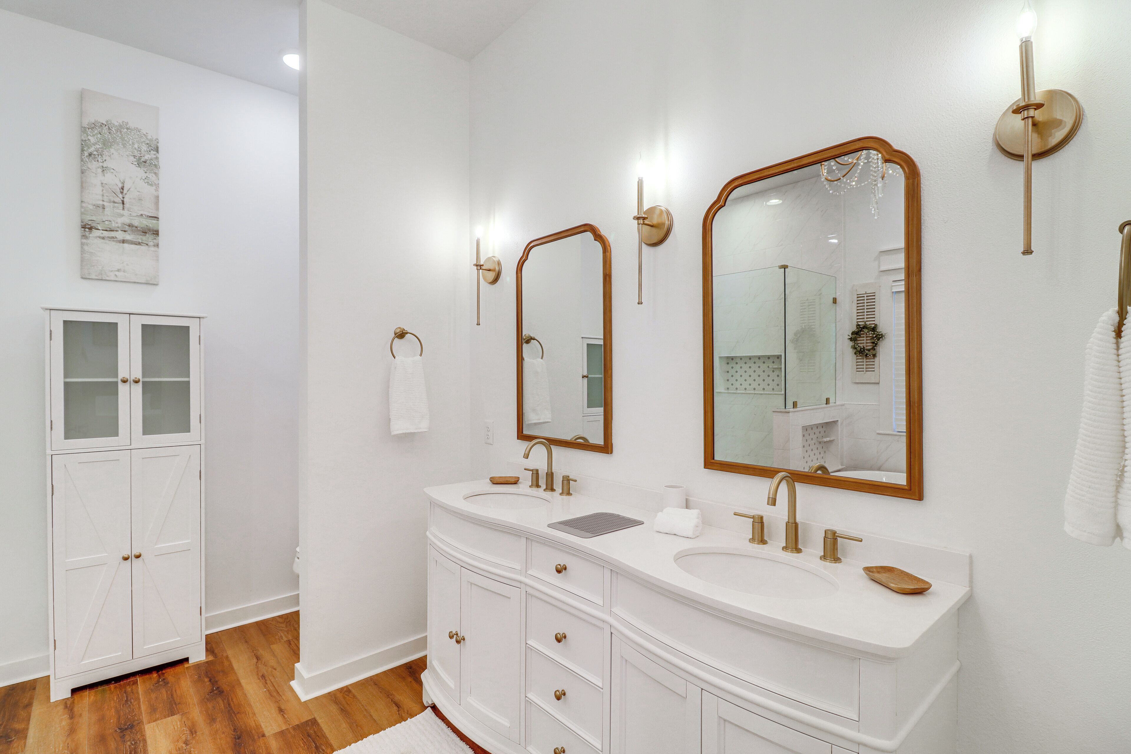Une salle de bain moderne avec deux lavabos, de grands miroirs et un meuble de rangement.