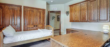 A bedroom with a wooden bed, a wooden desk, and a wardrobe.