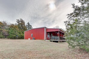 Situated in a serene grassy area, this charming barn-style building offers a peaceful retreat.