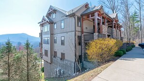 A multi-story building with a stone facade, large windows, and a balcony. - Chalakee Lodge CA-3- Mountain View, Gated Resort, Indoor/Outdoor Pools & Hot Tub (Boone)