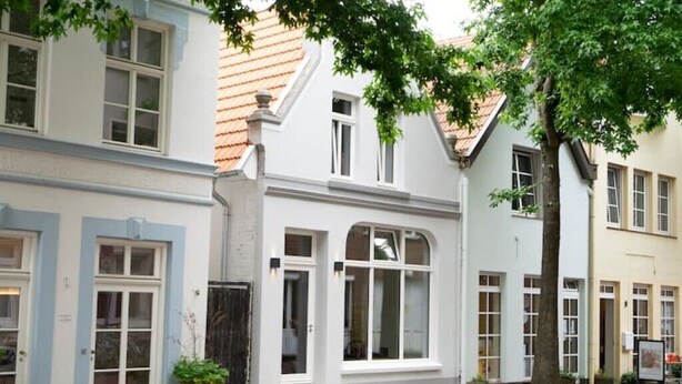 Une rangée de bâtiments de style européen traditionnel, avec des façades blanches et de nombreuses fenêtres.