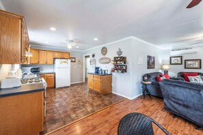 A compact living space with a kitchen, dining area, and a seating area with a sofa and armchair. - Songbird Haven Cozy Country Getaway (Waco)