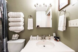 A bathroom with a toilet, sink, and towel rack.