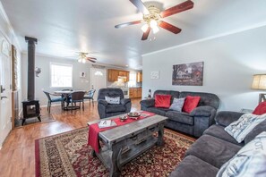 A living room with a fireplace, a sofa, a coffee table, and a dining area.