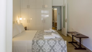 A hotel room with a bed, a table, and a wardrobe. - Casa Tsipa (Corfu)