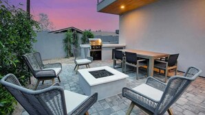 An outdoor patio area with a dining table, chairs, a fire pit, and a grill. - Scottsdale Retreat - Pool, Outdoor Grill, Firepit (Scottsdale)