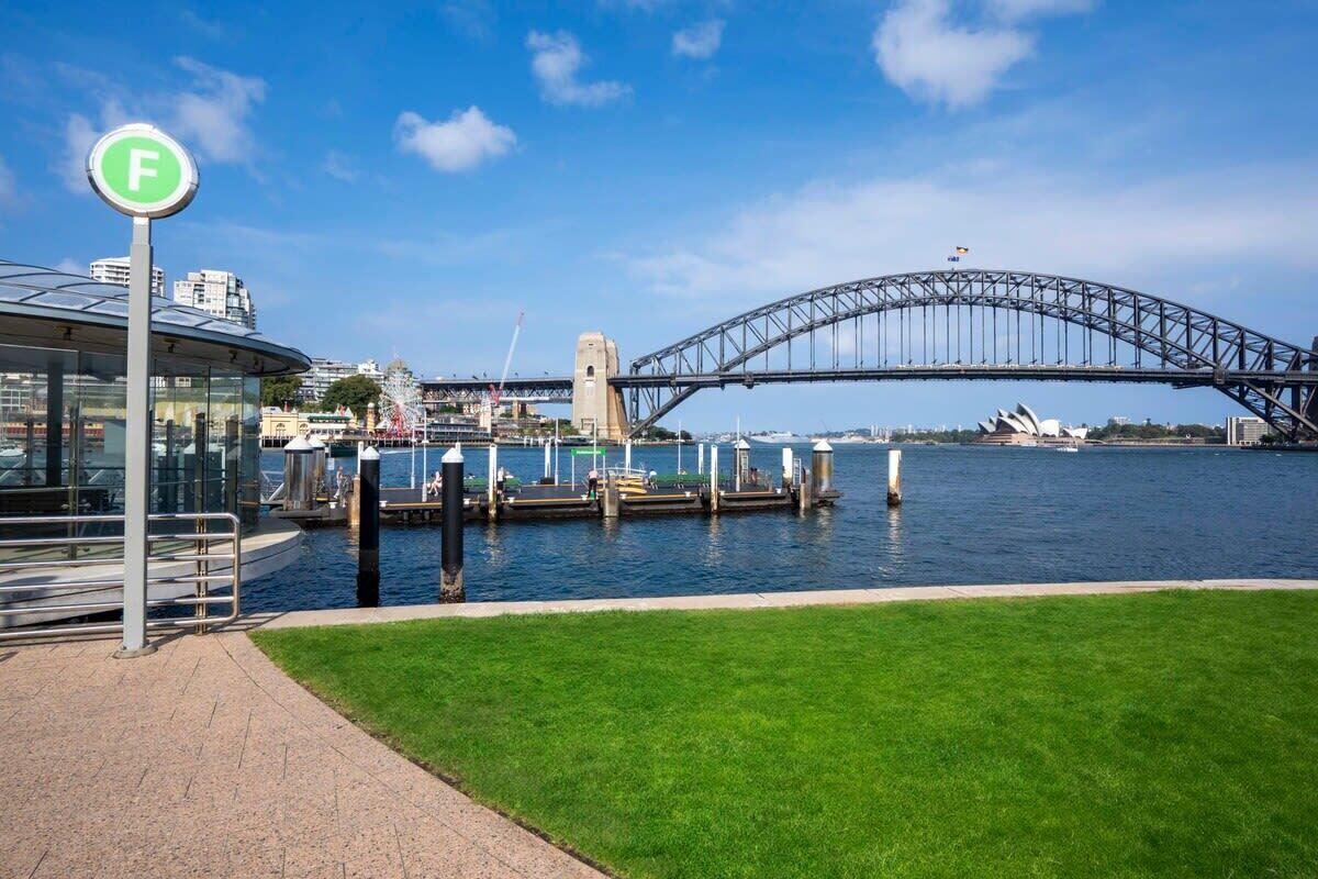 A waterfront view with a bridge, a glass building, and a sign with a letter 'F'.