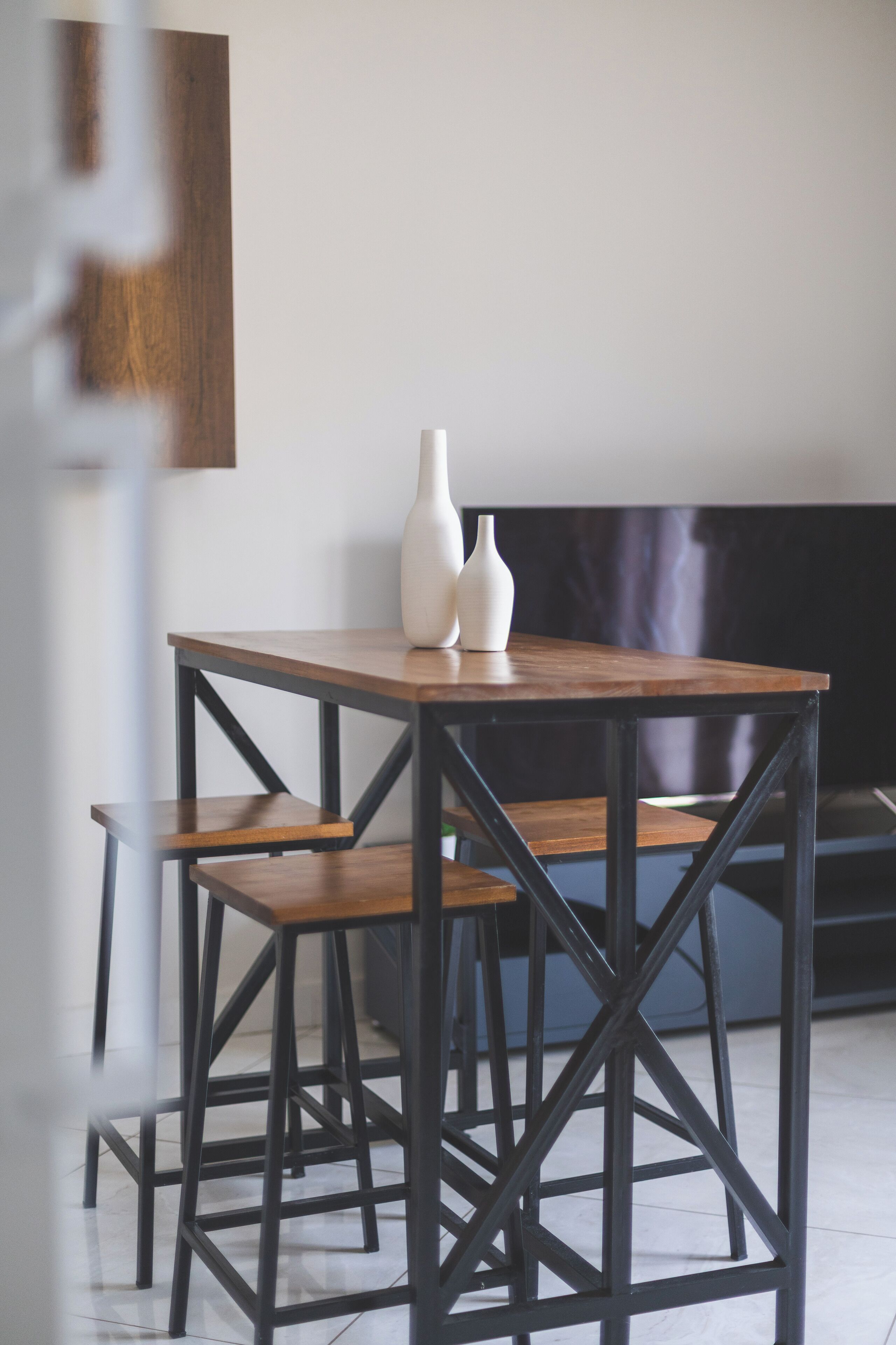 Un petit coin repas avec une table en bois et des chaises en métal noir.