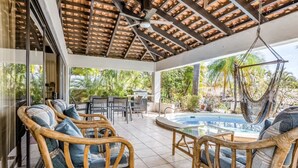 A covered outdoor area with wicker furniture, a pool, and a hammock. - Beautiful 3 bedroom and 2 bathrooms villa close to beach. (Playa Hermosa)