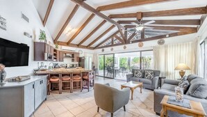 A spacious living area with a kitchen, dining area, and a large sliding glass door leading to an outdoor patio. - Beautiful 3 bedroom and 2 bathrooms villa close to beach. (Playa Hermosa)