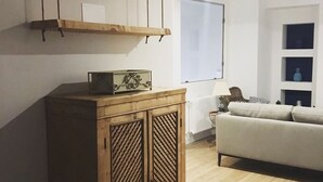 Un salon avec un meuble en bois, un canapé et un radiateur.