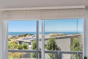 A view from a window with a clear view of the ocean and a residential area with solar panels. - Encounter Escape Encounter Bay (Encounter Bay)