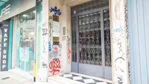 A storefront with a metal gate and graffiti on the wall. - Egnatia Central Spacious 3 Bd Apt (Thessaloniki)