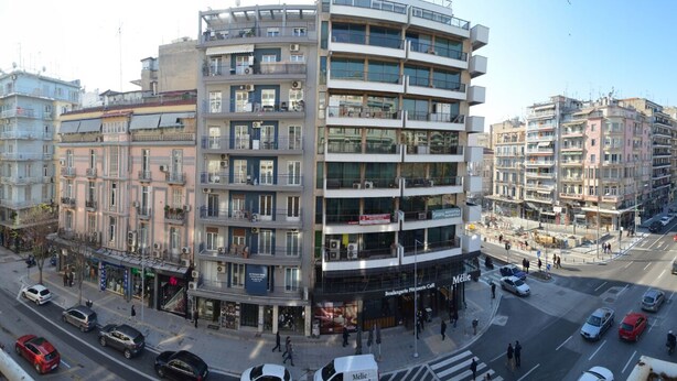 A multi-story building with balconies, a street in front, and cars parked along the road. - Egnatia Central Spacious 3 Bd Apt (Thessaloniki)