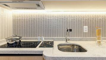 A modern kitchen with a built-in stove, a sink, and a backsplash.