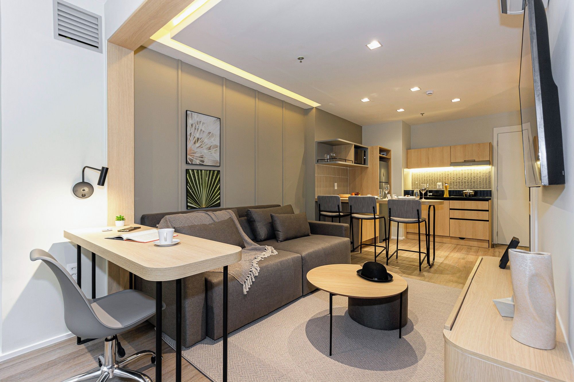 Una sala moderna con un sofá, una mesa de comedor y una zona de cocina.