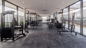A spacious gym with various exercise equipment, large windows, and a clean, modern design. - House of Charlie Pinheiros (São Paulo)
