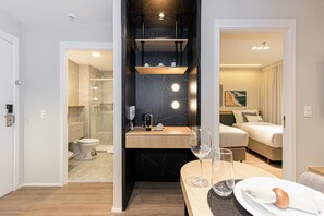 Ett modernt hotellrum med badrum, matplats och sovrum.