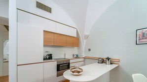 Eine moderne Küche mit weißen Schränken, einer Holz Arbeitsplatte und einer kleinen Kochinsel.