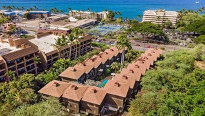 A resort with multiple buildings, a swimming pool, and a view of the ocean.