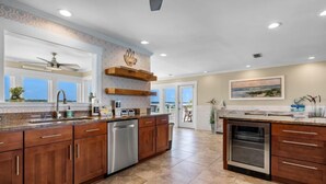 A spacious kitchen with a large island, wooden cabinets, a dishwasher, and a built-in oven. - Lagoon Front | Boat Dock & Fishing Pier | Sleeps 12 (Gulf Shores)