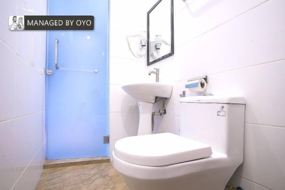 Ein Badezimmer mit Toilette, Waschbecken und einer blauen Tür.