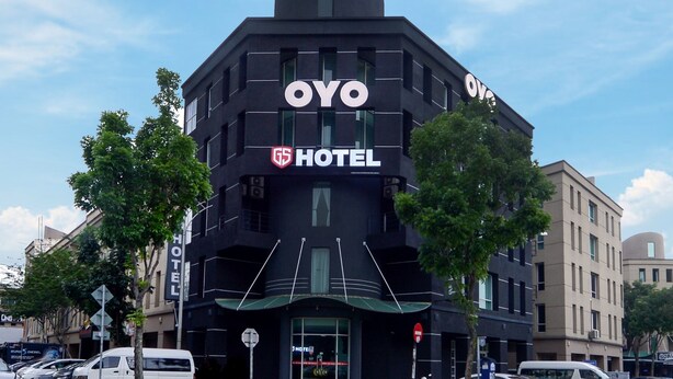 Ein schwarzes OYO Hotel Gebäude mit modernem Design, gekennzeichnet durch eine große Beschilderung und eine markante Dachkonstruktion.