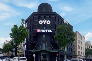 Un bâtiment noir de l’hôtel OYO, doté d’un design moderne, avec une grande enseigne et une structure de toit distinctive.
