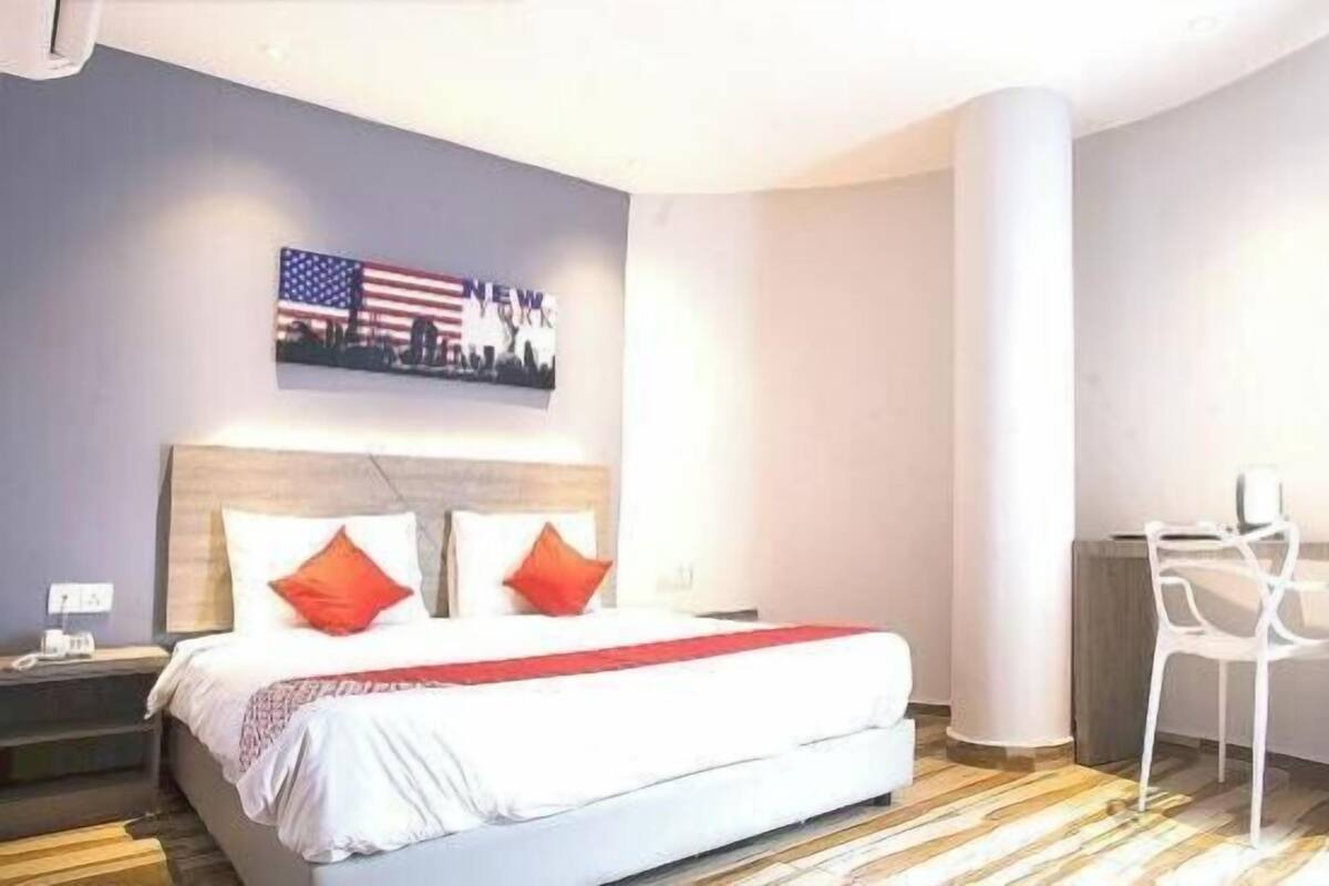 Une chambre d’hôtel avec un lit, un bureau et une chaise.