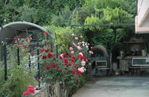 Un jardin avec un sentier, un banc en bois et une clôture en métal.