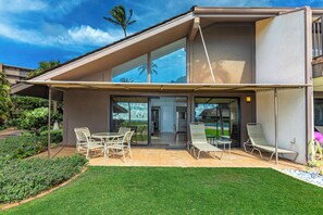 Una casa moderna con un patio, mobiliario exterior y vistas del paisaje circundante.