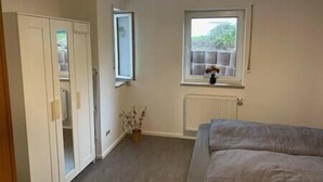 A bedroom with a bed, a radiator, a window, and a potted plant. - Apartment in the countryside near Koblenz, Apartment im Grünen bei Koblenz (Vallendar)