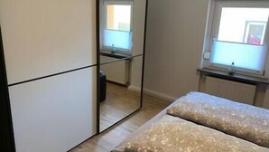 Une chambre à coucher avec un lit, une fenêtre et un miroir.