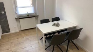 Une petite salle de réunion moderne, dotée d’une table blanche et de quatre chaises.
