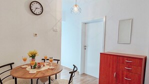 A dining area with a wooden table, chairs, and a red cabinet. - Lovely ground floor apartment with a sunny terrace (Mostar)