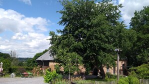 A rustic building with a gravel path leading to a wooden fence. - L'Ermite (Saint-Algis)