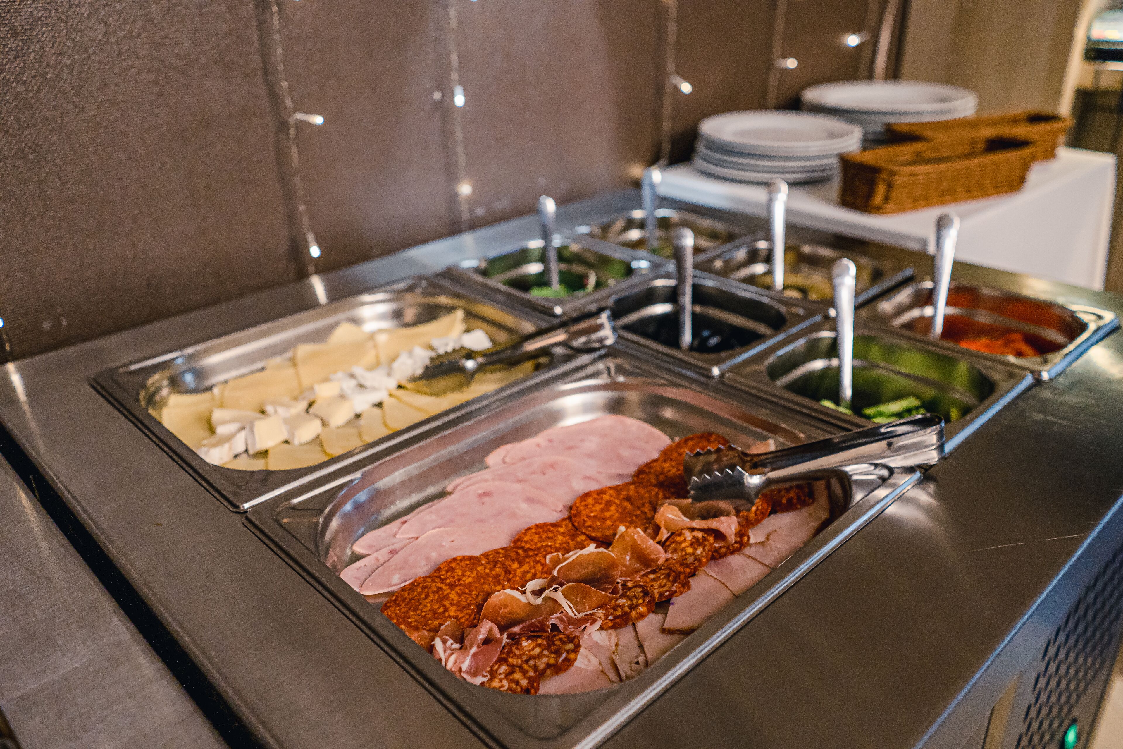 Un buffet proposant une variété de plats, notamment des viandes et des fromages en tranches.