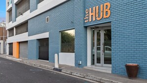 A building with a blue brick facade and a sign that reads "The HUB".