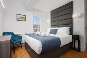 A modern bedroom with a large bed, a desk, and a chair. - 316 Reid's Corner - By Stay Dunfermline (Dunfermline)