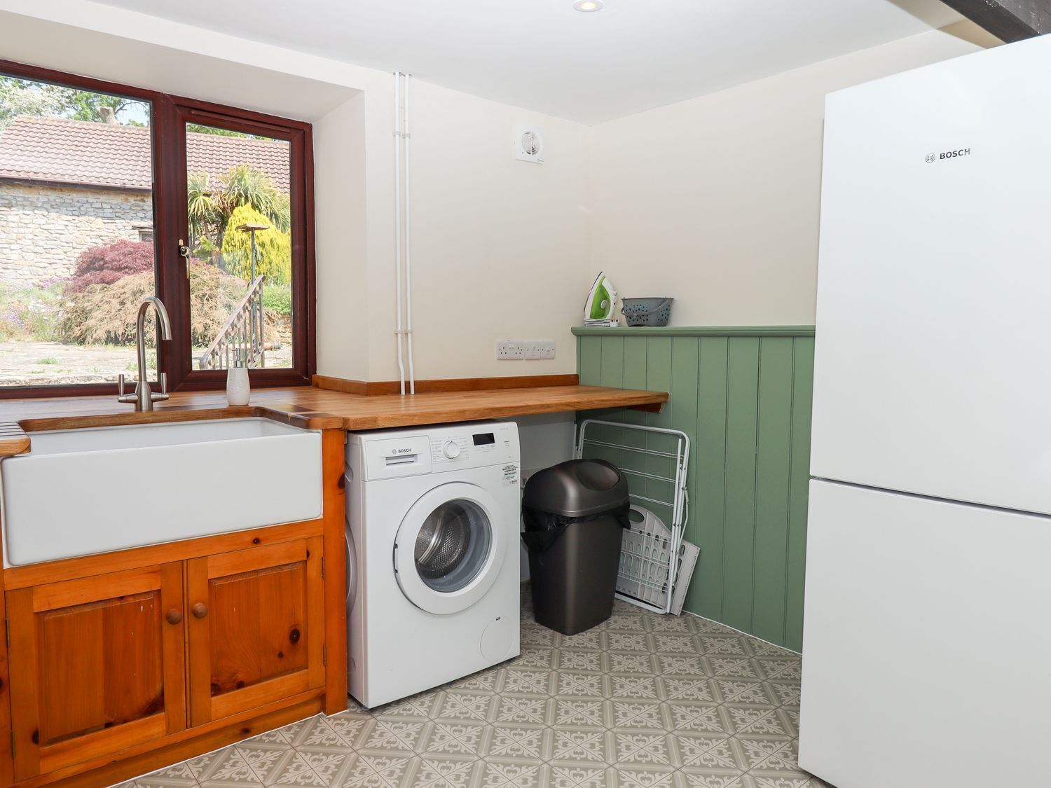 A compact kitchen with a washing machine, a sink, and a refrigerator.