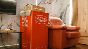 A vintage Coca-Cola refrigerator, a leather armchair, and a marble wall. - Búho Kite Hotel Boutique (Juan de Acosta)