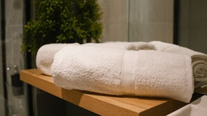 A wooden shelf with neatly folded white towels. - Búho Kite Hotel Boutique (Juan de Acosta)